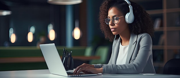 Mujer negra tomando notas durante el seminario web de la oficina usando una computadora portátil y usando auriculares con espacio vacío