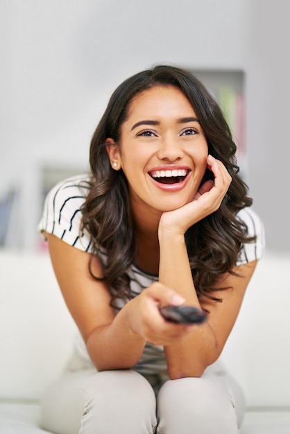 Mujer negra viendo medios de televisión y películas a distancia y transmisión de programas por cable o relájese en el sofá de la sala de estar o el sofá Mujer feliz disfrute de la transmisión de entretenimiento de televisión y la suscripción