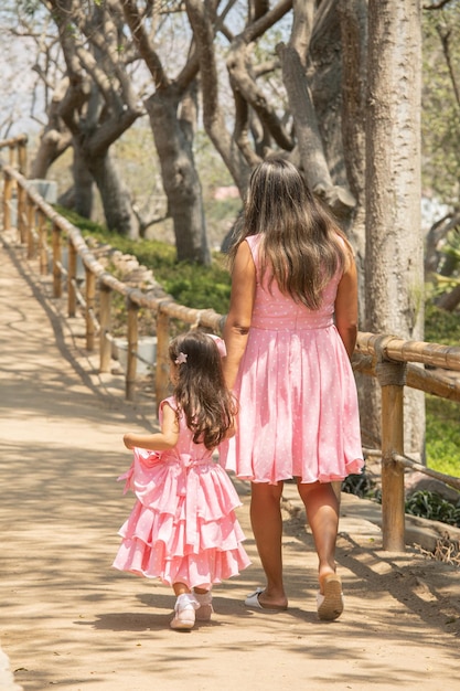 una mujer y una niña caminan por un camino