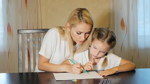 Mujer con niña dibujo sobre papel