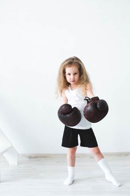 Mujer niña divertida con guantes de boxeo.