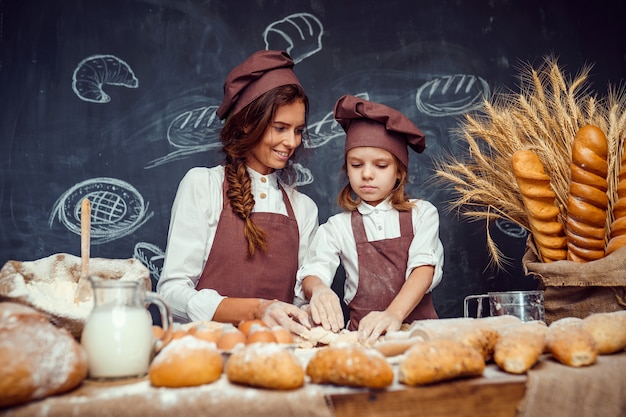 Mujer y niña haciendo pasteles juntos