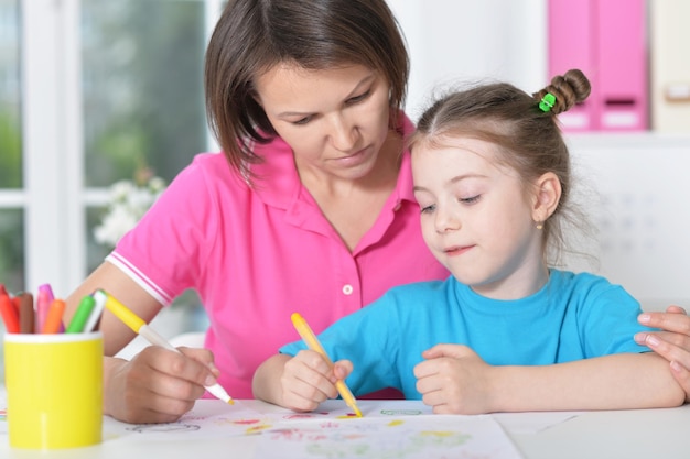 mujer y niña con lápices de colores