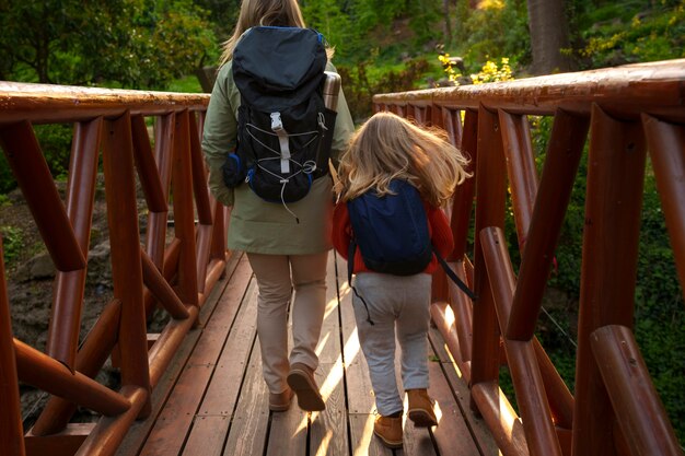 Foto mujer y niña de tiro completo explorando la naturaleza.