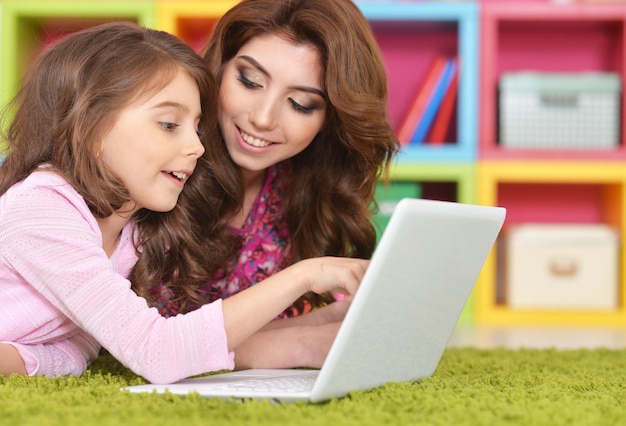 Mujer y niña usando laptop