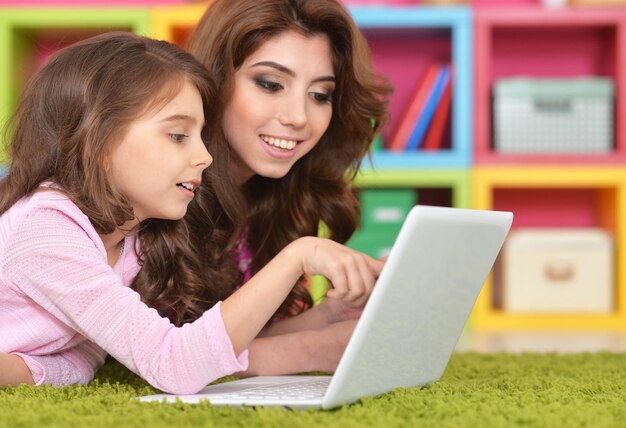 Mujer y niña usando laptop