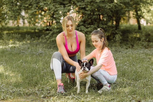 Mujer y niña van a pasear con su perro en el parque