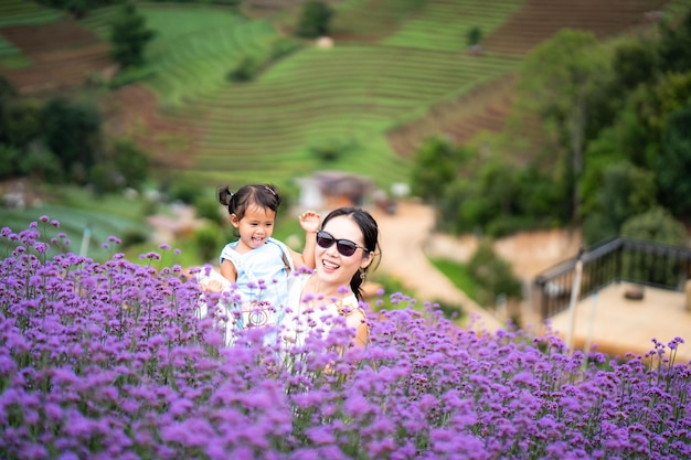 Una mujer y un niño en un campo de flores violetas.