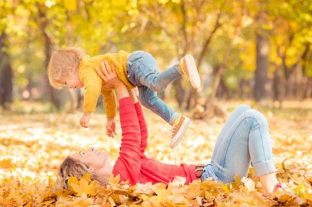 Mujer y niño divirtiéndose al aire libre en el parque otoño