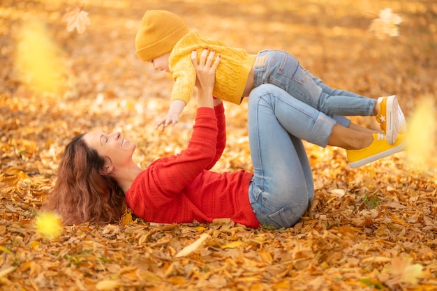 Mujer y niño divirtiéndose al aire libre en el parque otoño