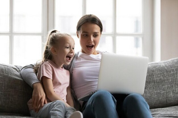 una mujer y un niño están mirando una computadora portátil