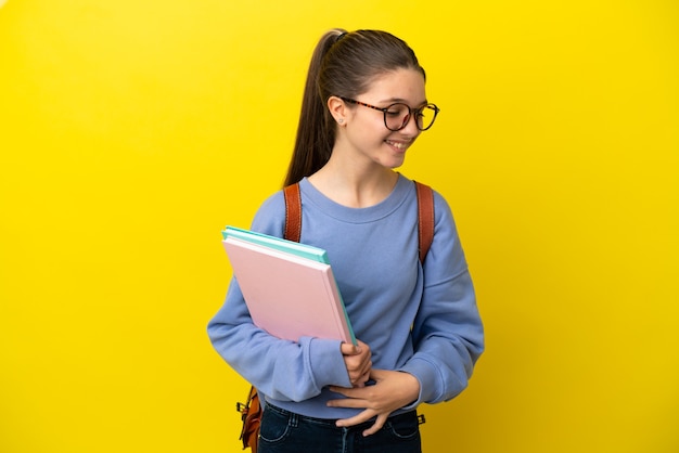 Mujer de niño estudiante sobre pared amarilla aislada sonriendo mucho