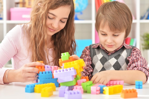 Mujer y niño jugando juntos con coloridos bloques de plástico