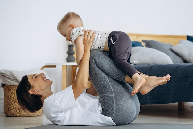 Mujer con niño practicando yoga en casa