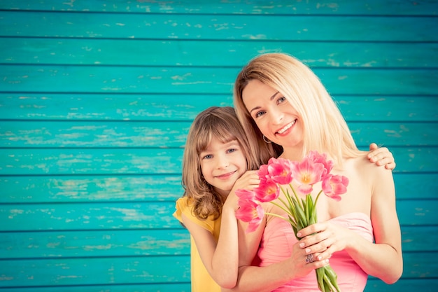 Mujer y niño con ramo de flores contra el fondo verde concepto de vacaciones familiares el día de la madre