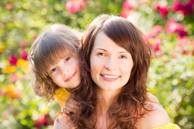 Mujer y niño con ramo de flores sobre fondo verde Concepto de vacaciones familiares de primavera Día de la madre