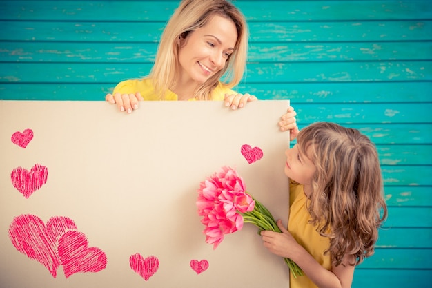 Mujer y niño con ramo de flores sobre fondo verde. Concepto de vacaciones familiares de primavera. Día de la Madre