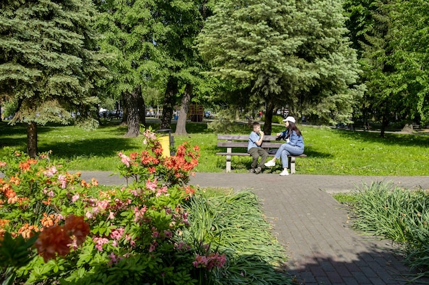 mujer, con, niño, sentado, en, el, banco, en, público, parque, niño, comida, helado