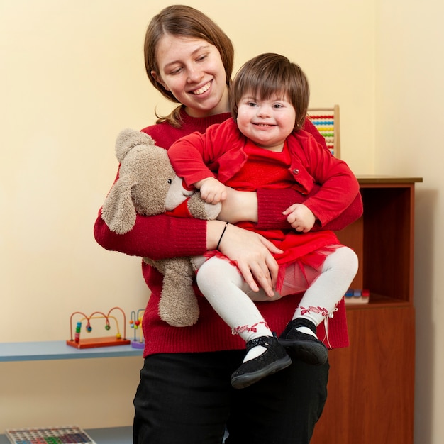 Foto mujer con niño sonriente con síndrome de down