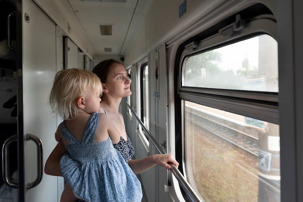 Mujer con niño viaja en tren. La familia viaja en el tren y mira por la ventana. Viaja en tren.