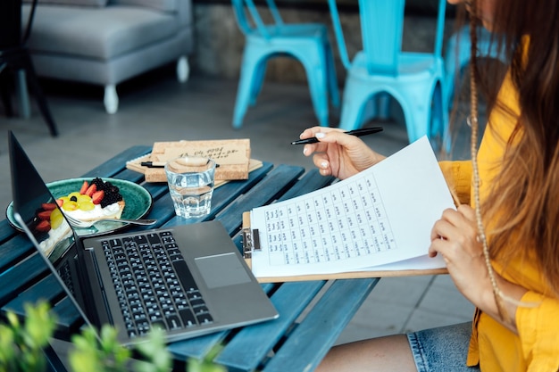 Mujer numeróloga que trabaja con números en el bloc de notas y en la computadora portátil numerología números concepto numerología