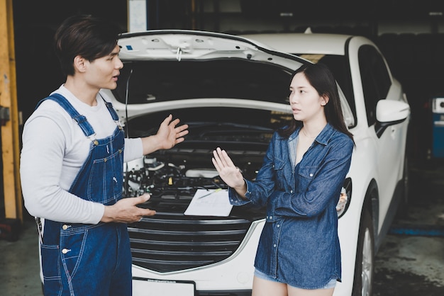 La mujer o el dueño en el automóvil levantan la mano rechazando los costos de reparación