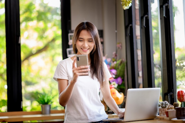 Una mujer o un estudiante feliz sonríe en un escritorio con una computadora