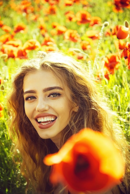 Mujer o niña feliz en el campo de la semilla de amapola