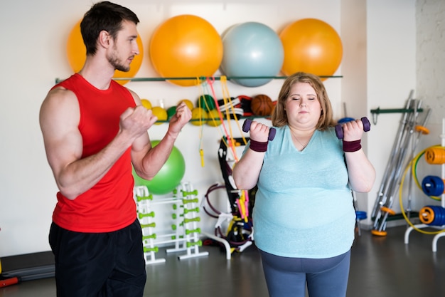 Mujer obesa en ejercicio en el gimnasio