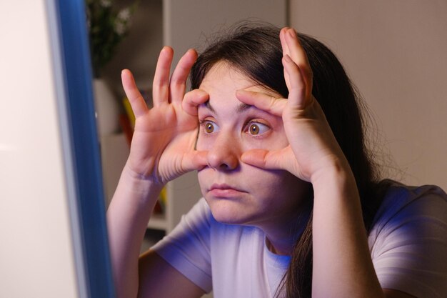 La mujer se obliga a mirar la pantalla de la computadora.