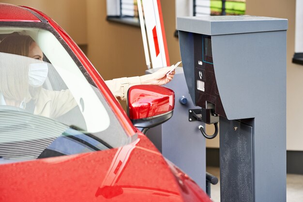 Mujer obteniendo el boleto del parquímetro en el estacionamiento subterráneo