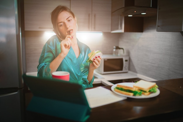 Mujer ocupada comiendo, bebiendo café, hablando por teléfono, trabajando en la computadora portátil al mismo tiempo. La empresaria realizando múltiples tareas