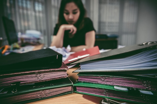 Mujer de oficina asiática estresada por la sobrecarga de trabajo Estresada porque debe enviar trabajo En el momento especificado Gente tailandesa Joven secretaria cansada del jefe por un nuevo proyecto