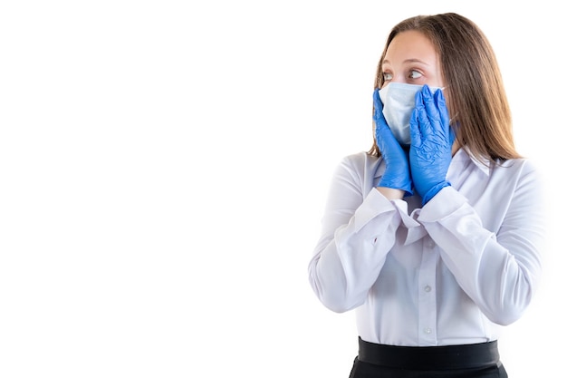 Mujer de oficina conmocionada Peligro de Covid19 Medidas de cuarentena Mujer de negocios preocupada en guantes de máscara de medicina sosteniendo las manos en la cara mirando espacio de copia aislado en blanco Fondo publicitario