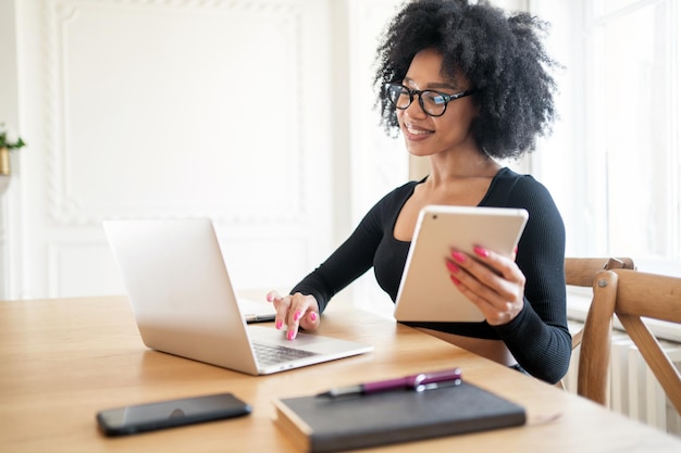 Una mujer en la oficina está trabajando con una computadora portátil