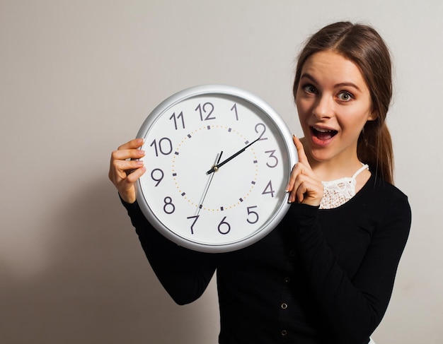 mujer, en, oficina, con, grande, reloj blanco