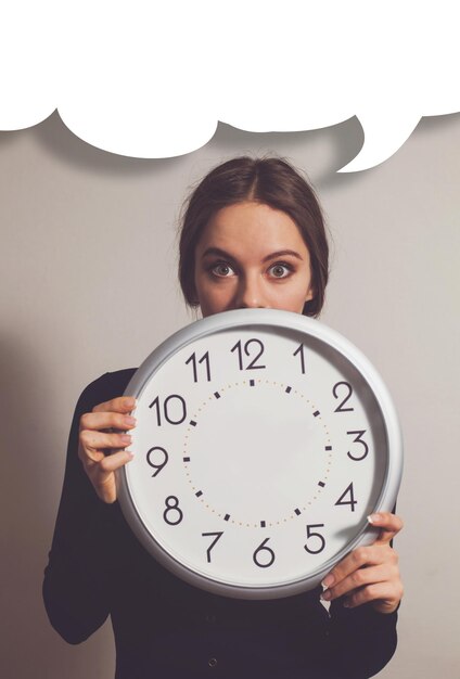 Foto mujer, en, oficina, con, grande, reloj blanco