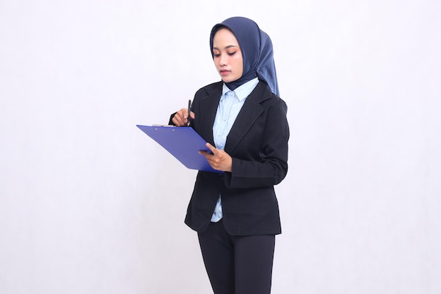 Mujer de oficina madura de Indonesia con hijab se para elegantemente sosteniendo un bolígrafo mientras lleva y p
