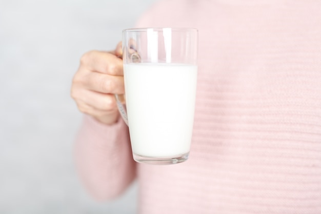 La mujer ofrece beber una taza de leche.