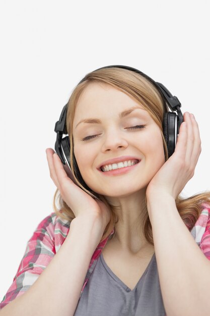 Mujer con los ojos cerrados escuchando música