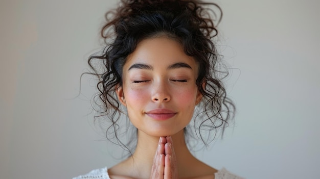 Foto mujer con los ojos cerrados y las manos juntas