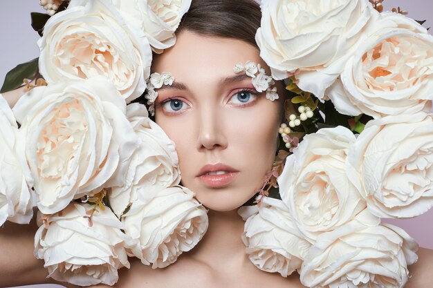 Mujer de ojos maquillaje de primavera con flores blancas.