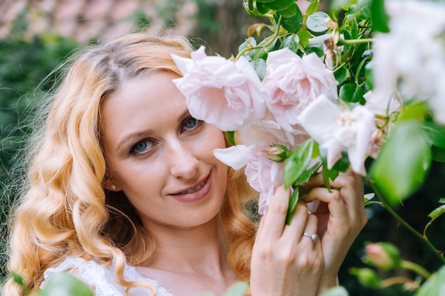 Mujer oliendo y disfrutando de hermosas rosas