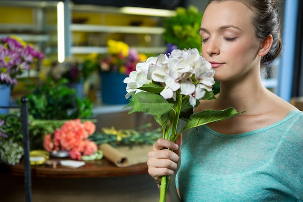 Mujer oliendo un ramo de flores