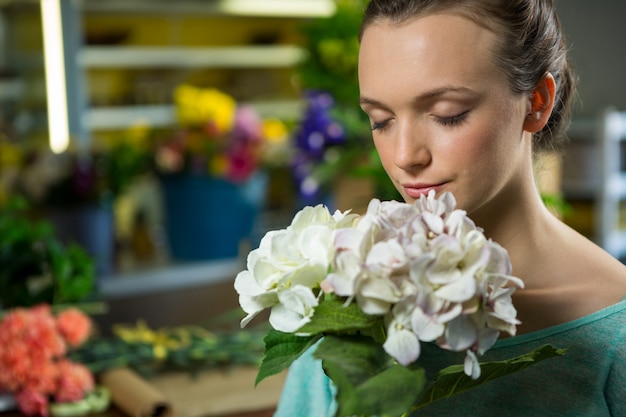 Mujer oliendo un ramo de flores