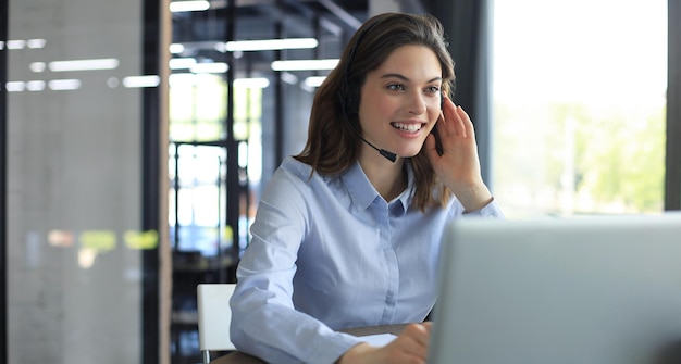 Mujer operador de soporte al cliente con auriculares y sonriente