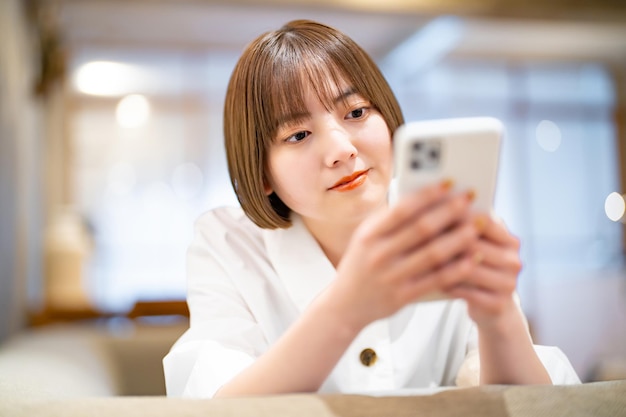 Una mujer operando un teléfono inteligente en la habitación.