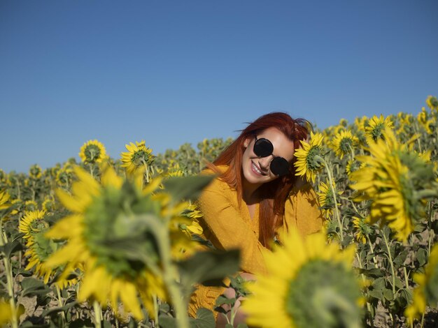 Mujer optimista en plantación con girasoles.