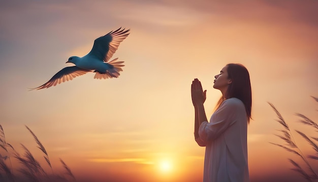 Foto mujer orando y pájaro libre disfrutando de la naturaleza en el fondo del atardecer concepto de esperanza