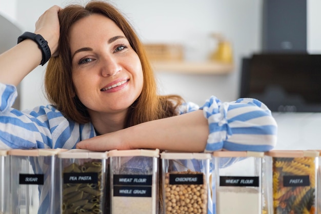 Mujer organizadora de espacio profesional sonriendo posando con cajas para un cómodo almacenamiento de productos